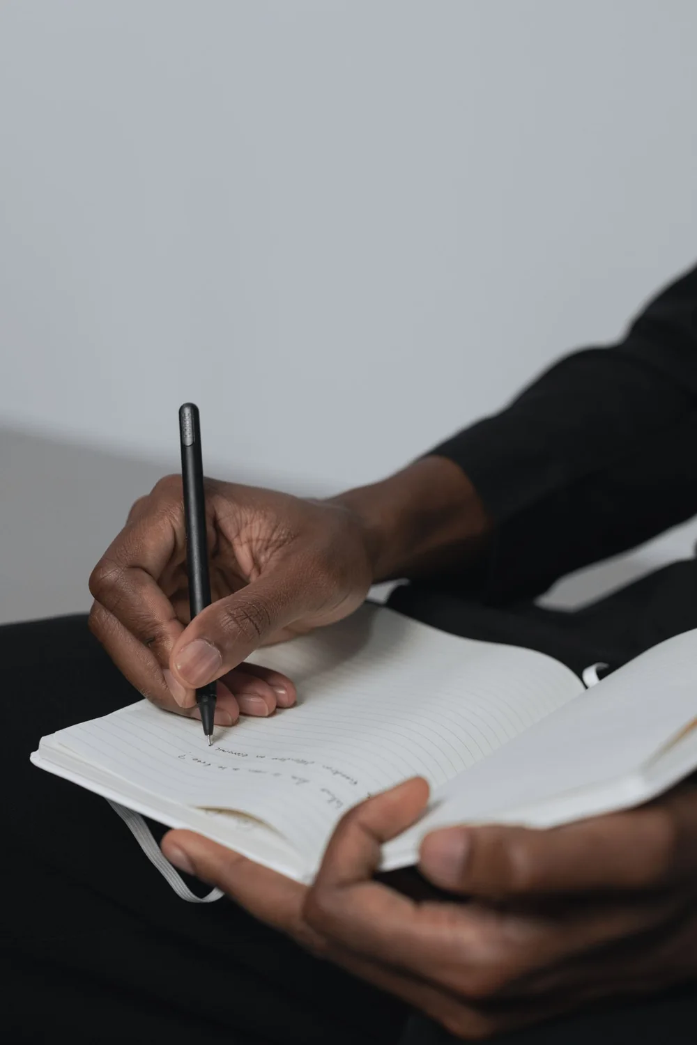 Una mano da forma a sus ideas escribiendo en un cuaderno